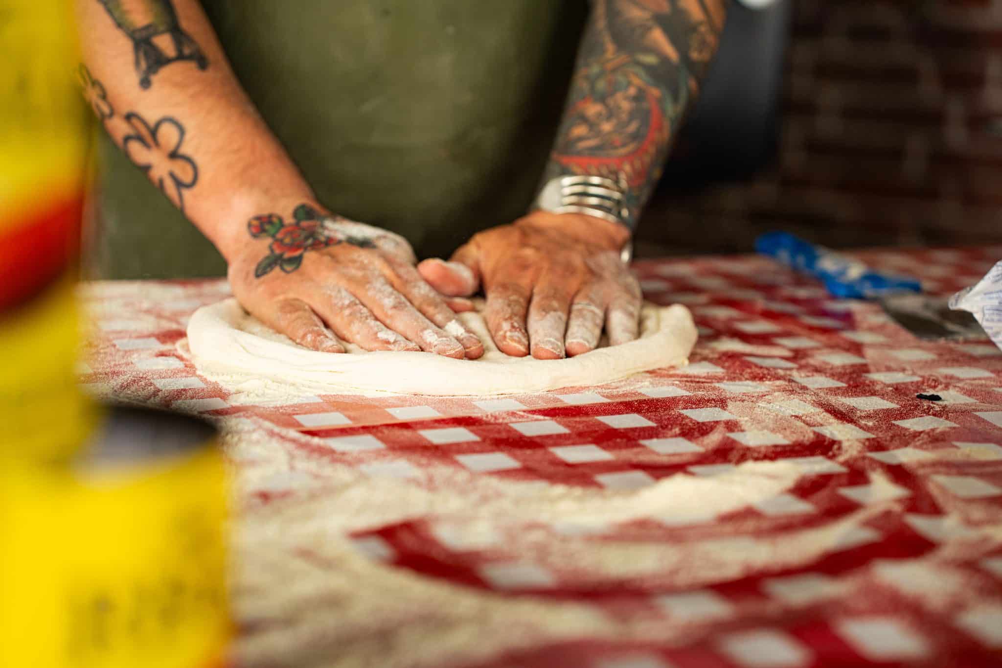 Thomas stretcht pizzadeeg met de hand