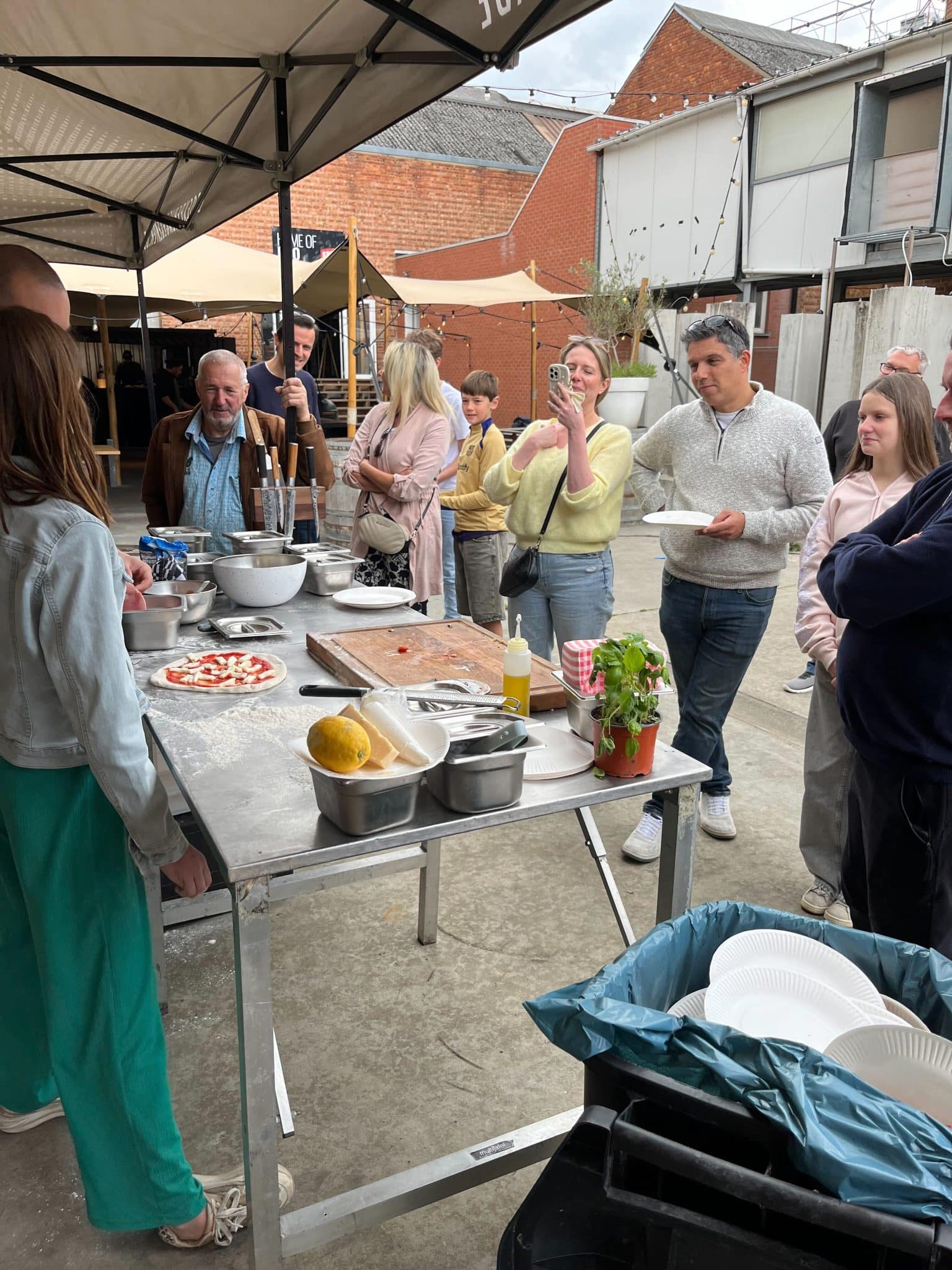 Bezoekers proeven en kletsen rond de tafel